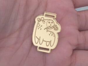 passador de elastico chato 7mm - Capivara com Flor- espelhado Dourado - pct c/05 und